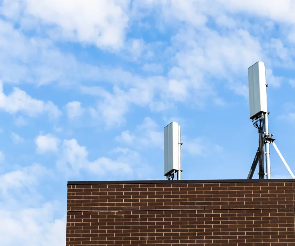 Dos antenas verticales sobre un techo de ladrillo de edificio