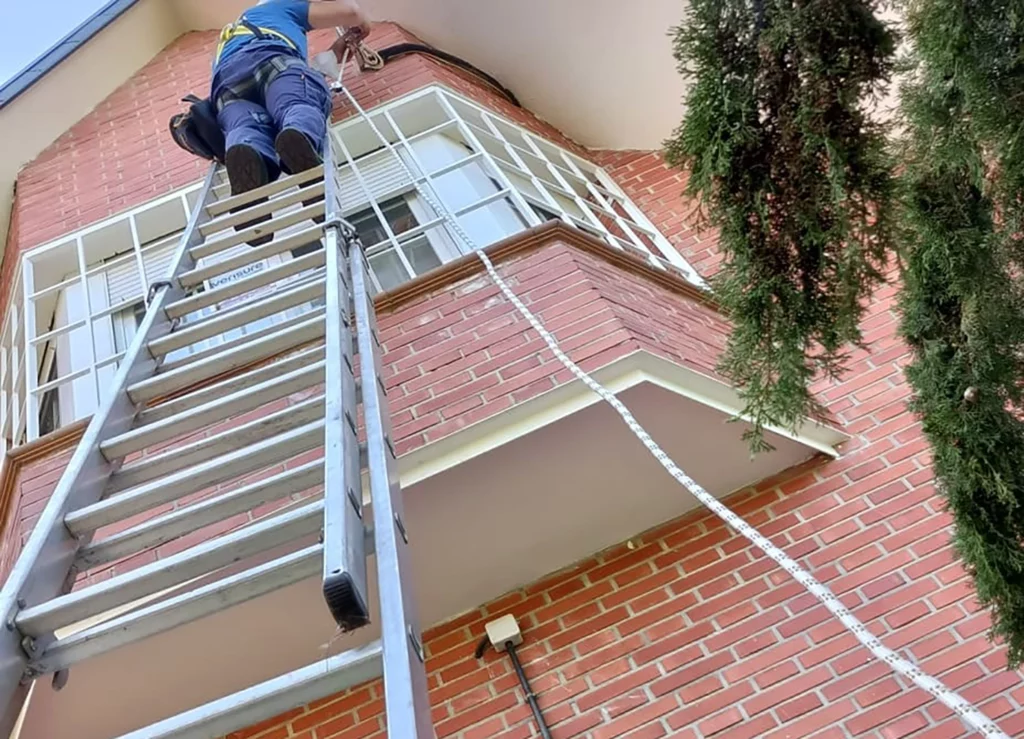 Trabajador haciendo una instalación en el exterior de una casa